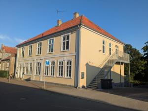 a large white building with a staircase in front of it at Stubbekøbing Square View Stopover in Stubbekøbing