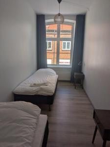 a room with two beds and a window at Stubbekøbing Square View Stopover in Stubbekøbing