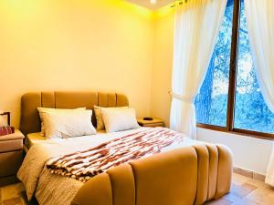 a bedroom with a bed and a large window at Highland by Gunner Lodges in Patriata
