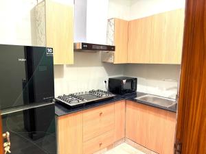 a small kitchen with a stove and a microwave at Highland by Gunner Lodges in Patriata