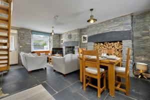 a living room with a stone fireplace and a table and chairs at Finest Retreats - Garreg Ddu in Blaenau-Ffestiniog
