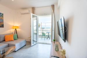 a living room with a couch and a sliding glass door at Vrachati Blue in Vrachati