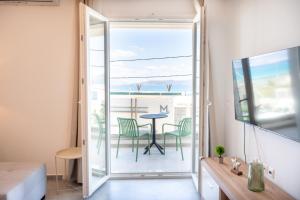 a room with a balcony with a table and chairs at Vrachati Blue in Vrachati