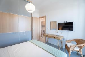 a bedroom with a bed and a desk and a television at Vrachati Blue in Vrachati +170 photos