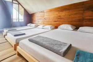 a row of four beds in a room at Cozzy Villa TB & Outbond in Riunggunung +19 photos