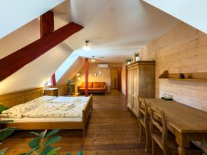 a room with a bed and a table and chairs at Pivovarský hotel in Dalešice