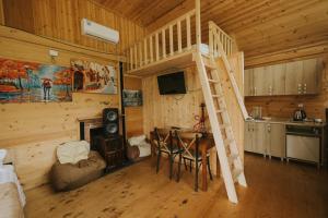 a room with a loft bed and a table in a cabin at River Land Cottages in Tsʼkhmorisi