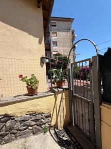 an open gate to a balcony with potted plants at Alloggio turistico La casetta di Piazza Roma in Bracciano