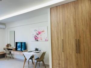 a dining room with a white table and a wooden cabinet at Georges Estates Hotel in Stoupa
