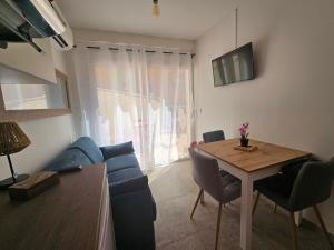 a living room with a blue couch and a table at Appartements sur l'ile de Porquerolles in Porquerolles