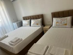 a bedroom with two beds with towels on them at f & xh apartaments in Kavajë
