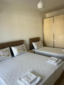 a bedroom with two beds and a mirror at f & xh apartaments in Kavajë