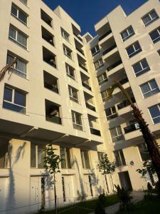a large white building with trees in front of it at f & xh apartaments in Kavajë
