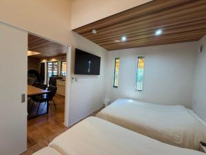 a bedroom with two beds and a dining room at テラスKawazu in Kawazu +64 photos