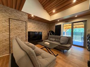 a living room with a couch and a tv at テラスKawazu in Kawazu