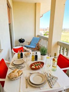 a table with food and wine on a balcony at Villa Ida in Capo Rizzuto