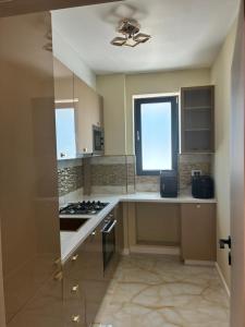 a kitchen with a stove and a window in it at Penthouse Rico in Eforie Nord +6 photos