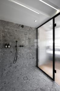 a bathroom with a shower with a glass wall at Hotel Bleibe in Freudenberg am Main +35 photos