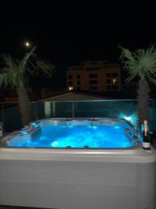 a jacuzzi tub with a bottle of beer next to it at Penthouse Rico in Eforie Nord