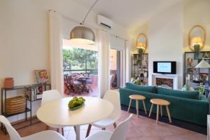 a living room with a couch and a table and chairs at bwelcome aroeira beach & golf in Charneca