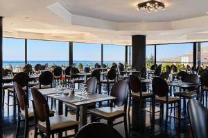 a restaurant with tables and chairs with the ocean in the background at Anezi Tower Hotel in Agadir