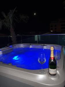 a bottle of wine and two glasses in a hot tub at Penthouse Rico in Eforie Nord