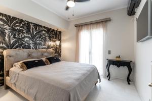 a bedroom with a bed and a large window at Mythodea Luxury Villa Ι Sunset Horizon & Jacuzzi in Naxos Chora