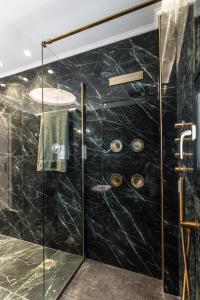 a bathroom with a shower with a glass door at Mythodea Luxury Villa Ι Sunset Horizon & Jacuzzi in Naxos Chora +32 photos