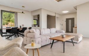 a living room with white couches and a table at White Sand Loutraki Villa - Sea View in Loutraki