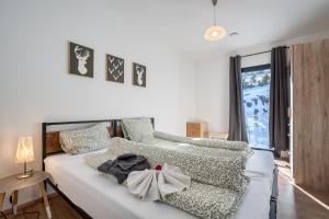 a bedroom with a white bed and a window at Mountain Chalet Top 3- mit Garten und Grill in Fieberbrunn