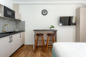 a kitchen with two bar stools in a room at Apartmani Ivano & Anđelo in Međugorje
