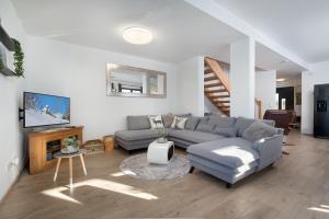 a living room with a couch and a tv at Mountain Chalet Top 3- mit Garten und Grill in Fieberbrunn