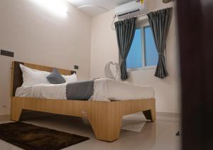 a bedroom with a wooden bed with a window at NRI Hotels & Coliving in Hyderabad