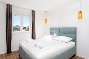 a bedroom with a bed with two white towels on it at Apartmani Ivano & Anđelo in Međugorje