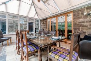 a dining room with a wooden table and chairs at 4 Bed in Matlock oc-52094 in Highpeak Junction