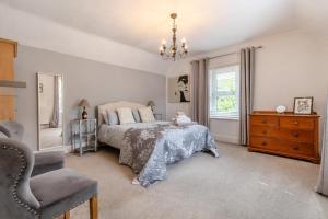 a bedroom with a bed and a dresser and a chair at 4 Bed in Matlock oc-52094 in Highpeak Junction