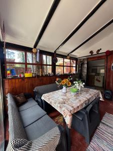 a dining room with a table and a couch at Chalet Rustique-Covasna in Covasna