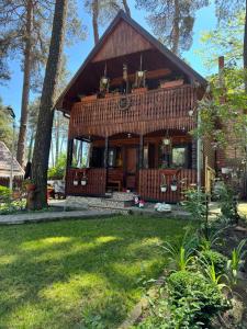 a log cabin with a porch in a yard at Chalet Rustique-Covasna in Covasna