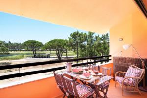 a balcony with a table and chairs and a window at bwelcome aroeira beach & golf in Charneca