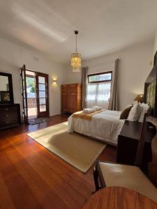 a large bedroom with a bed and a chandelier at Open plan apartment in Muizenberg in Muizenberg