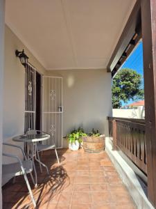 a balcony with a table and chairs and a table at Open plan apartment in Muizenberg in Muizenberg +19 photos