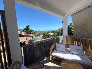 a balcony with a bed and chairs on a balcony at Makeda in Chiconi