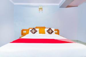 a bedroom with a large bed with red and white sheets at Hotel Shaan- M I Road City Centre in Jaipur
