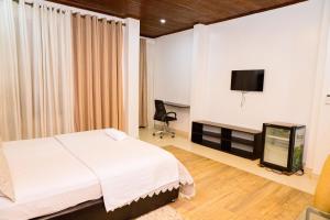 a bedroom with a bed and a flat screen tv at Poolside View Guest House in Kigali