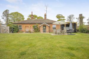 a brick house with a lawn in front of it at 3 Bed in Northrepps oc-k29801 in Cromer