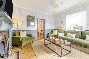 a living room with two green couches and a table at 3 Bed in Northrepps oc-k29801 in Cromer