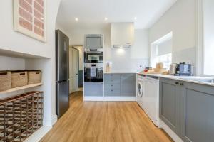 a kitchen with blue cabinets and white appliances at 3 Bed in Northrepps oc-k29801 in Cromer