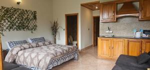 a bedroom with a bed and a kitchen with a sink at Green's Cottage in Nathia Gali
