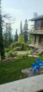 a blue bench in a yard next to a house at Green's Cottage in Nathia Gali