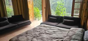 a living room with a couch and a large window at Green's Cottage in Nathia Gali